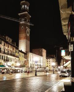 una calle de la ciudad con una torre del reloj por la noche en Vista Apartments Verona, en Verona