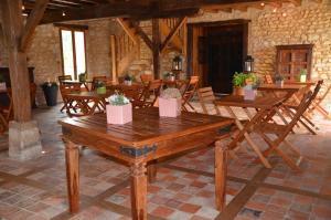 a dining room with wooden tables and chairs at Château de Mazières in Tendu