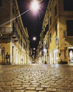 una calle vacía por la noche con una persona caminando por la calle en Vista Apartments Verona, en Verona