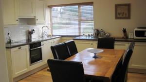 a kitchen with a wooden table and black chairs at Glengarth in Penryn