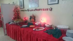 una mesa con un mantel rojo y un árbol de Navidad en Pilgrim's Guest House, en Madaba