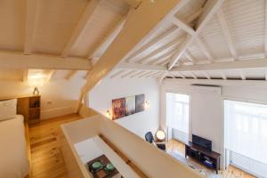 ポルトにあるOporto Mezzanine - by ML Apartmentsの白い壁と木製の天井の広いリビングルーム
