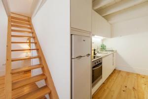 a kitchen with a staircase next to a refrigerator at Oporto Mezzanine - by ML Apartments in Porto