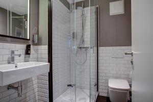 a bathroom with a shower and a sink and a toilet at NYCE Hotel Hamburg City in Hamburg