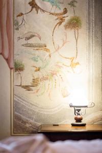 ベルガモにあるDOLCE VITA Citta Altaの絵の前のテーブルの灯り