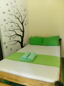 a bed with two towels on it with a tree mural at Greenhut Pension & Bar in Jagna