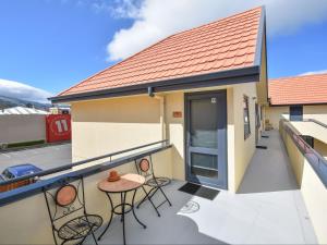 - un balcon avec des chaises et une table dans un bâtiment dans l'établissement Bella Vista Motel Dunedin, à Dunedin
