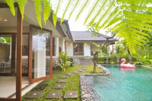 a house with a swimming pool in front of a house at Amara Giri I in Ubud