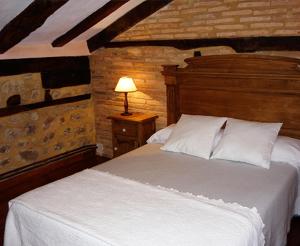 1 dormitorio con 1 cama blanca y 1 lámpara en Posada Vallejo en Periedo