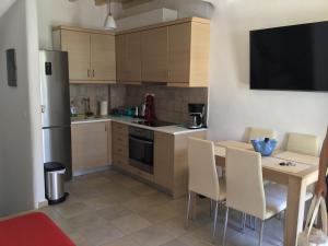 a kitchen with a table with chairs and a television at Mykonos efis maisonette in Mikonos