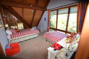 a small room with two beds and windows at Ruddles Retreat in Maleny