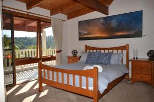 a bedroom with a bed and a balcony at Ruddles Retreat in Maleny