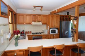 a kitchen with wooden cabinets and a white counter top at Ruddles Retreat in Maleny
