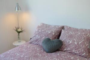 a heart pillow sitting on top of a bed at Oporto Cozy House in Porto