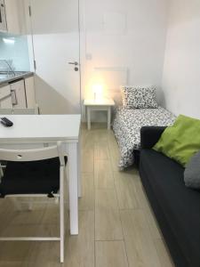 a room with a desk and a couch and a bed at Oporto Cozy House in Porto