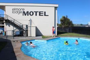 eine Gruppe von Personen in einem Schwimmbad in der Unterkunft Elmore Lodge Motel in Hastings