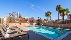 a swimming pool with two chairs and a fence at Best Western Poway/San Diego Hotel in Poway