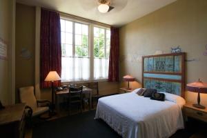 a bedroom with a bed and a desk and a window at McMenamins Kennedy School in Portland