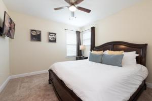 a bedroom with a large bed with a ceiling fan at Disney Dreams Luxury Home with Private Water Park in Orlando