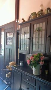 una cocina con un armario con un jarrón de flores en Mooltan House, en Hepburn Springs