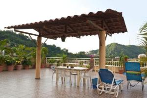 a patio with a table and chairs under an umbrella at Oasis Hostel in Puerto Vallarta