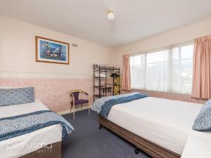 1 Schlafzimmer mit 2 Betten und einem Fenster in der Unterkunft Hobart Apartments in Hobart