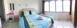 um quarto com uma cama com um urso de peluche em Happy Home Guest House em Ban Phe
