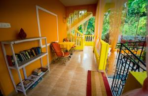 a hallway with yellow walls and a table and chairs at Orange Villa in Morjim