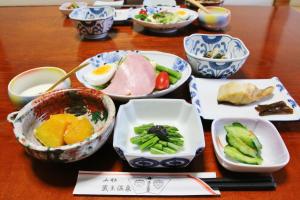 a wooden table with bowls of food on it at Takasagoya Ryokan in Zao Onsen