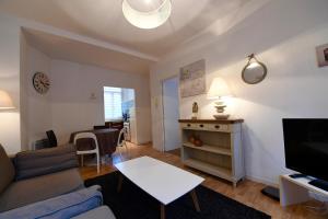 Appartement Week-end في دونكيرك: غرفة معيشة مع أريكة وتلفزيون