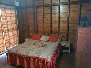 una camera da letto con un letto con cuscini rossi di Los Nogales a Punta Del Diablo