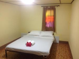 sypialnia z łóżkiem z czerwoną kokardą w obiekcie Time 2 Resort w mieście Pai
