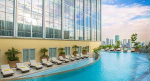 un hotel con una piscina con tumbonas y un edificio en Winford Resort and Casino Manila en Manila