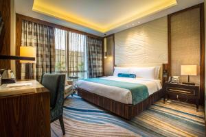 una camera d'albergo con letto e scrivania di Winford Resort and Casino Manila a Manila