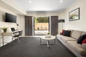 a living room with a couch and a table at Quest Mont Albert in Box Hill