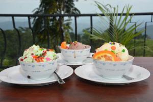 three bowls of ice cream on plates on a table at Discovery Retreat Blackwood in Haputale