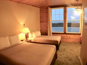 una camera d'albergo con due letti e una finestra di Hanging Horn Lakeside Resort a Moose Lake