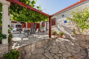 an outdoor patio with a table and chairs at Countryside Family Villa with Private Pool in Donje Selo na Šolti