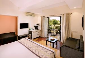 um quarto de hotel com uma cama e uma sala de estar em Sterling Kanha em Kānha