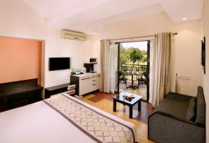 a hotel room with a bed and a living room at Sterling Kanha in Kānha