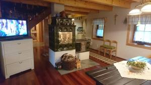 a living room with a stove and a tv at Chata ObšÍvanka in Terchová