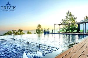 - une piscine dans un complexe avec des montagnes en arrière-plan dans l'établissement Trivik Hotels & Resorts, Chikmagalur, à Chikmagalur