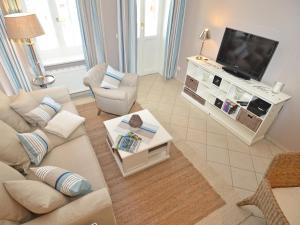a living room with a couch and a tv at Villa Fernsicht - Apt. 01 in Ostseebad Sellin