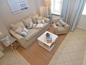 ein Wohnzimmer mit einem Sofa und einem Stuhl in der Unterkunft Villa Fernsicht - Apt. 01 in Ostseebad Sellin