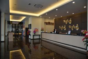 a hotel lobby with a woman sitting at a counter at Casa Bonita Hotel in Melaka