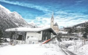 Eine Kirche ist vor der Tür mit Schnee bedeckt in der Unterkunft Jugend- und Familiengästehaus Heiligenblut in Heiligenblut