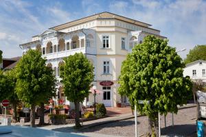 a white building with trees in front of it at Villa Fernsicht - Apt. 03 in Ostseebad Sellin