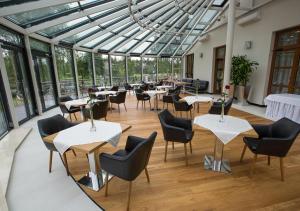 restauracja ze stołami i krzesłami oraz szklanymi sufitami w obiekcie Hotel KARO w Radomiu