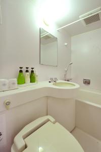 W łazience znajduje się umywalka, toaleta i lustro. w obiekcie Hotel Toms w Tokio