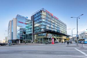 a large glass building on the corner of a street at Apartment24 - Foorum in Tallinn